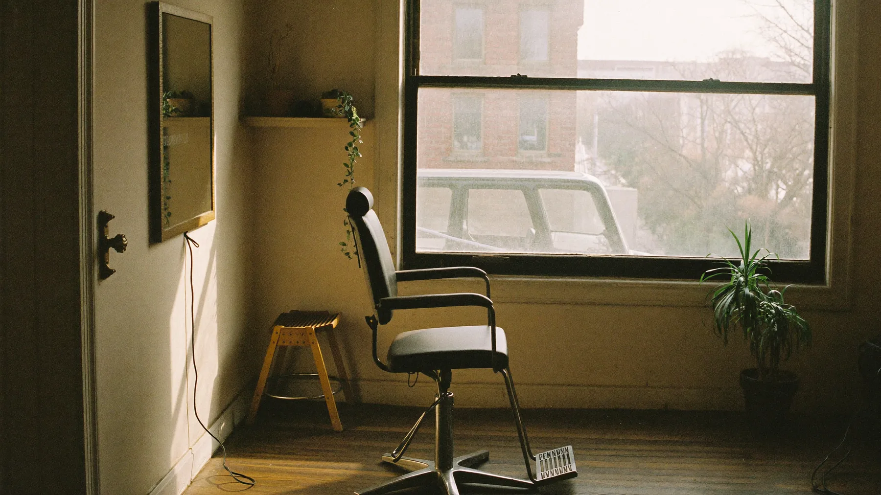 Empty styling chair beside a large window in soft morning light